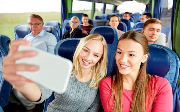 Chicas sonrientes se hacen una foto en un bus